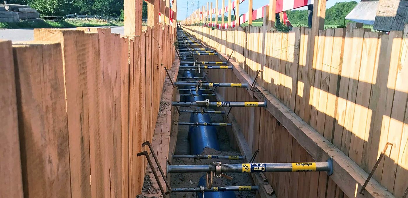 Photo: Pipeline in open trench, formwork and wooden barriers on the left and right